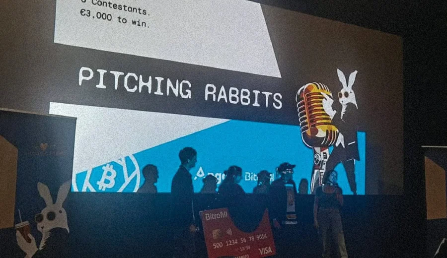 Bitcoin FilmFest 2025 Pitching Rabbits award ceremony, silhouettes of contestants on stage against the competition screen showing €3,000 prize.